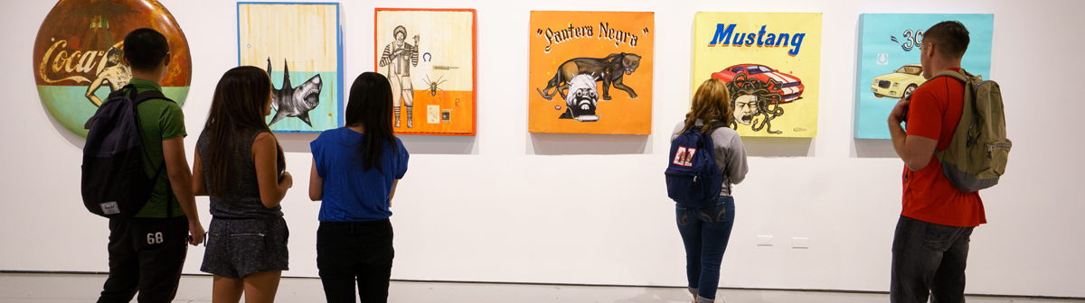 students look at paintings on the wall in the art gallery