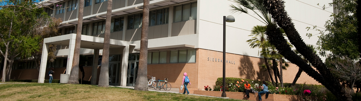 students sit in front of the Sierra Hall 