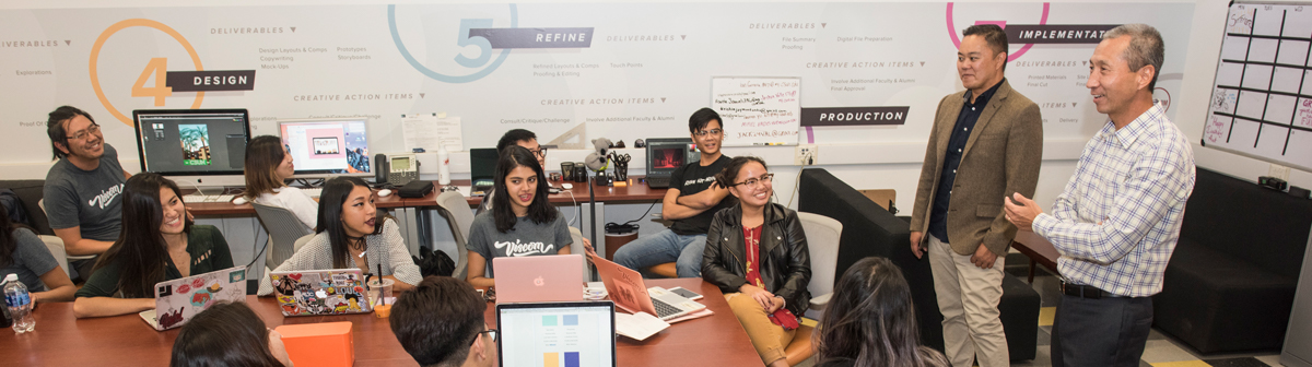 faculty speak with their students inside a classroom