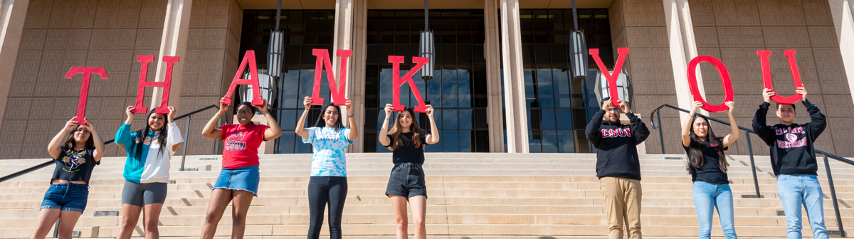 students hold letters that spell out thank you. 