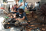 Student outside working on a car.