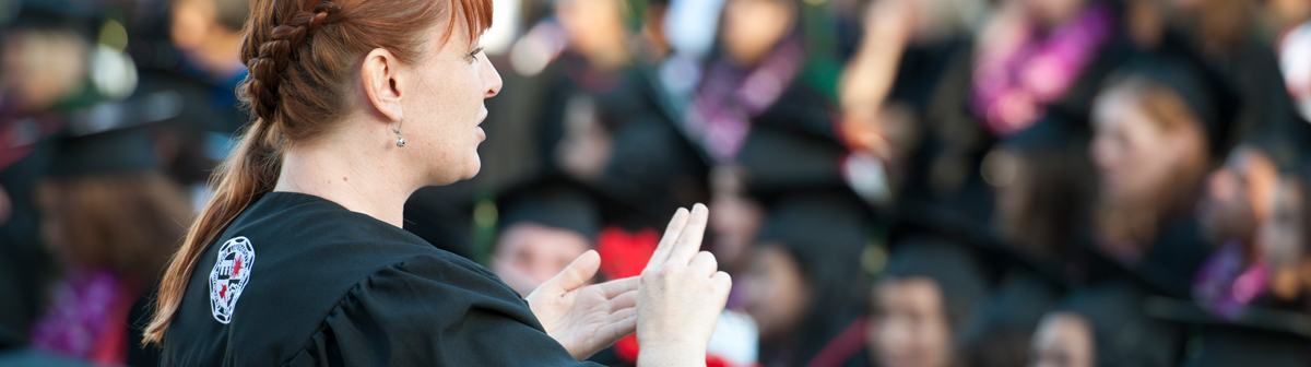 a student signs at a crowd at a commencement