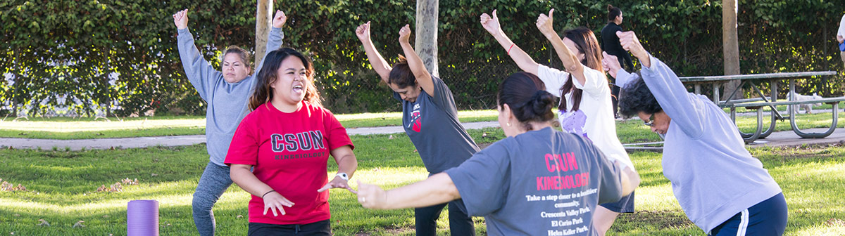 an instructor shows people an exercise outside 