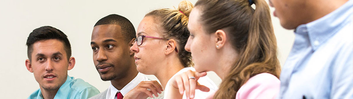 a woman speaks to a group of students in a classroom