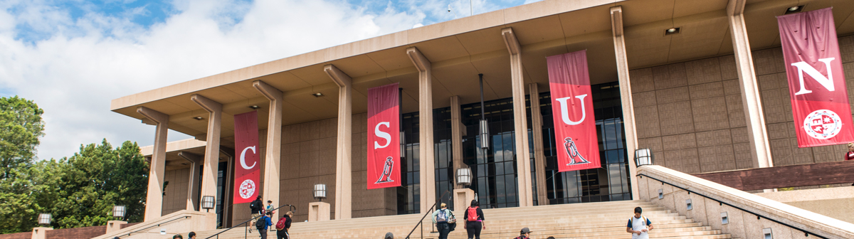 students walk up the steps to the Oviatt Library