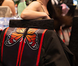 Jacket with butterfly logo draped over chair.
