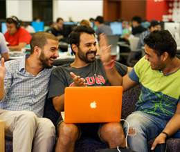 students sit inside the library and laugh together