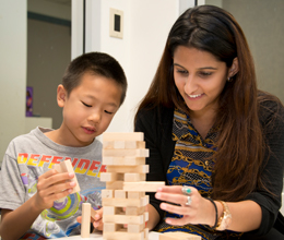 a teacher helps a small child play with blocks