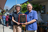 Two individuals holding up a award outside