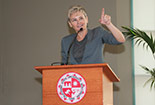 A female speaker talking on a podium.