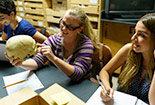 Students looking at bones on a table.