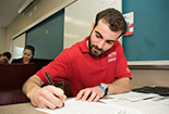 A student filling in papers at a desk