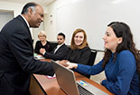 A professor shaking the hand of a student in class.