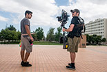 Two Students with a camera rig standing in front of Oviatt.