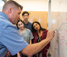 Jonathan Kelber teaching students at the whiteboard.