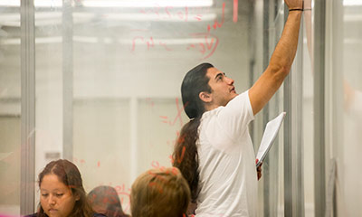A Student writing on a white board.