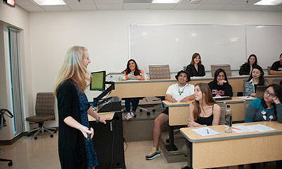 Teacher talking in front of class to students.