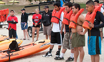 Students being taught at the edge of a lake