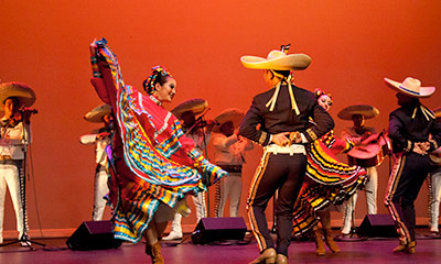 Two individuals dancing in traditional clothes