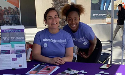 Two women sitting outside smiling to a camera