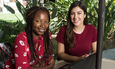 Two female CSUN Students sitting together.