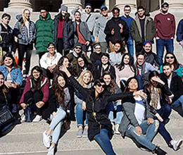 Students sit in a grass area and study