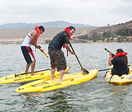 students help a man go into a pool